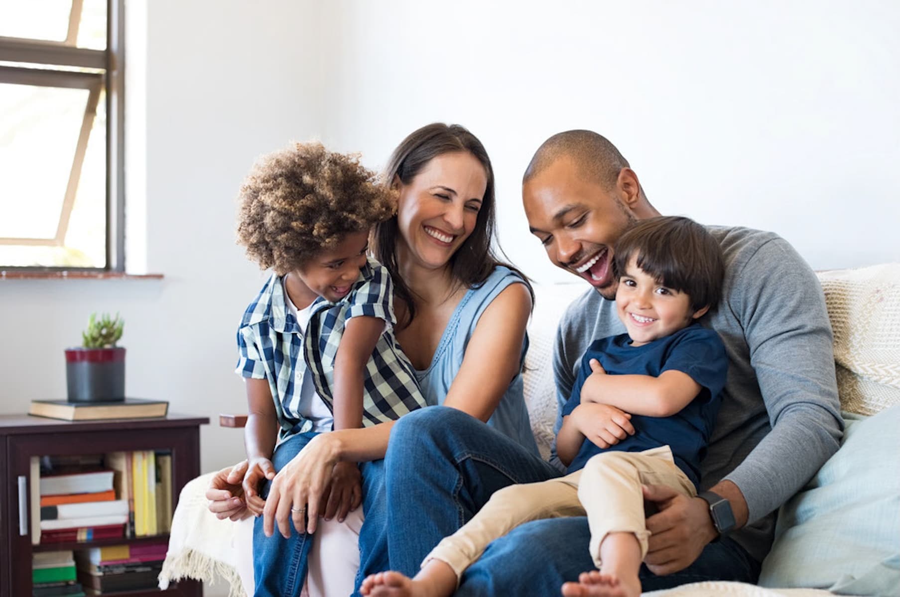 Family gathered around a kitchen table playing a card game — Thryve Family Care family membership
